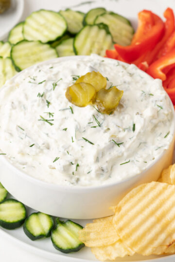 top view of dill pickle dip with chips and pickles