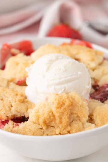 Strawberry Dump Cake in bowl with ice cream