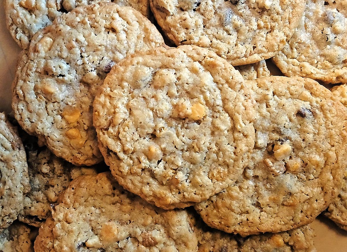 A close-up of several homemade oatmeal ice cream scoop cookies with visible oats and chocolate or butterscotch chips stacked together.