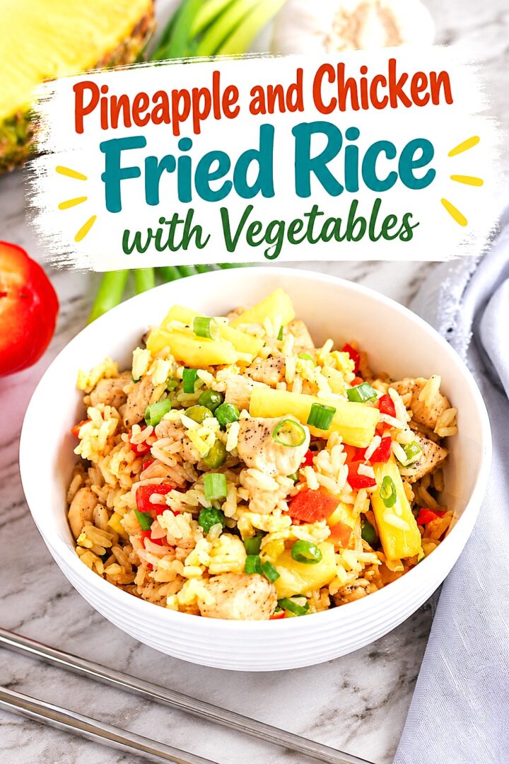 A white bowl of pineapple fried rice with chicken and vegetables sits on a table. The colorful dish includes rice, chicken, pineapple, red pepper, and green onions. Text above reads, Pineapple and Chicken Fried Rice with Vegetables.