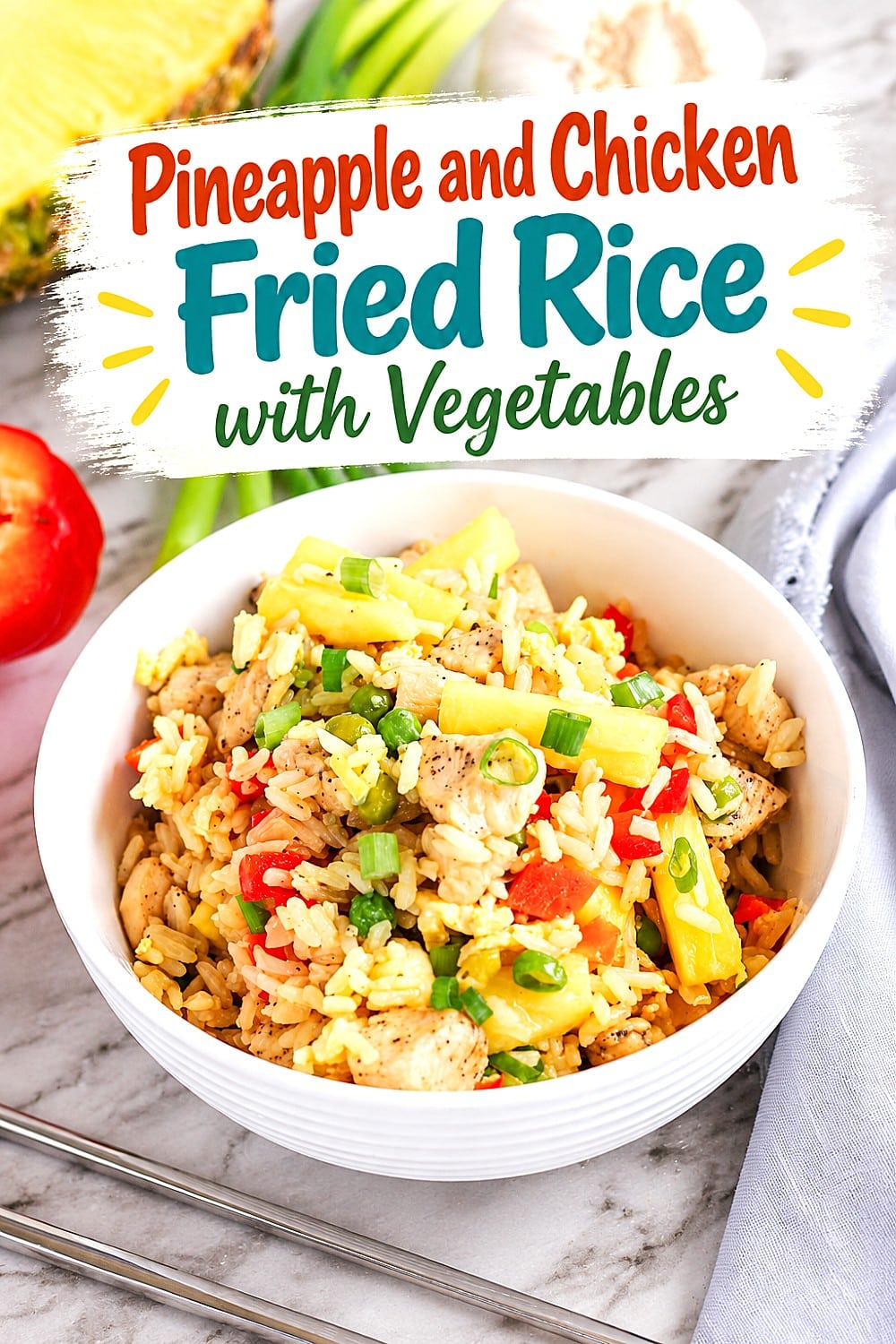 A white bowl of pineapple fried rice with chicken and vegetables sits on a table. The colorful dish includes rice, chicken, pineapple, red pepper, and green onions. Text above reads, Pineapple and Chicken Fried Rice with Vegetables.